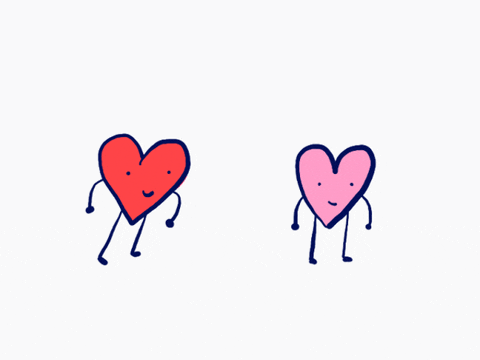 Cartoon gif. One red and one pink cartoon heart with arms and legs stand against a white background. The red heart leaps next to the pink heart, the two embrace and a heart emanates from above them. 