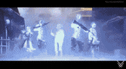 Video game gif. A group of five futuristic warriors suddenly appear out of nowhere with a brief flash of electricity. The teleported characters, dressed in high-tech armor and wielding various weapons, stand, side-by-side, looking around in confusion in the dramatic, fog-filled, dark, and industrial setting suggesting they don’t know where they have been teleported.