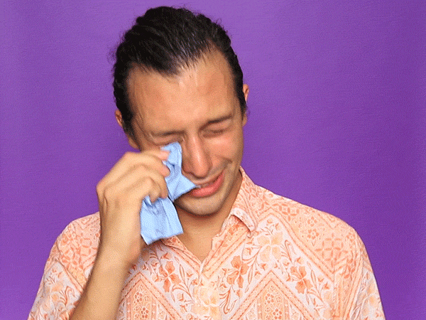 Video gif. A man dramatically dabs away tears as he cries, his shoulders shaking.