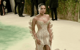 Met Gala 2024 gif. Mona Patel wears a structured gown featuring a butterfly-shaped corset and scalloped train. Her full length sleeves have kinetic butterflies that flare out to the sides, fixed with the mechanics to make the wings flutter back and forth. 