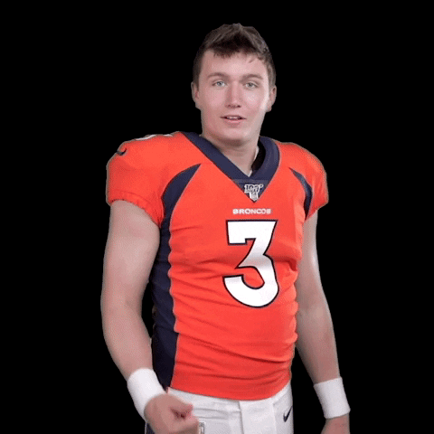 Sports gif. Quarterback Drew Lock is geared up in his orange Broncos jersey. He gives us a thumbs up before immediately thinking twice, shaking his head, and turning it into a thumbs down while giving us a teasing smile.