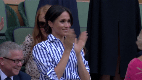 Celebrity gif. Meghan Markle is giving the players at Wimbleton a standing ovation.