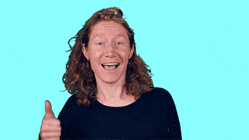 Video gif. Closeup of person giving an enthusiastic thumbs up with wide eyes and a gaping smile.