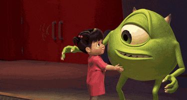 Disney gif. In a scene from Monster’s Inc, Mike gives Boo a gentle hug and she leans her cheek into his, smiling sweetly.