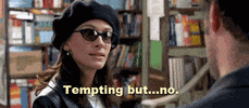Movie gif. Julia Roberts as Anna in Notting Hill wears sunglasses inside a bookstore as she speaks to a man in front of her. Text, "Tempting but... no."