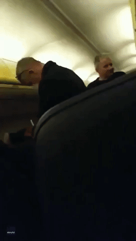 Ryanair Flight's Disembarking Delayed as Masked Personnel Assess Passenger