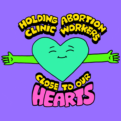 Digital art gif. Smiling green cartoon heart hugs its arms tightly around itself calmly. Yellow and pink text, in an all-caps cartoon-style font, reads, "Holding abortion clinic workers close to our hearts," against a purple background.
