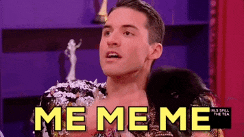Reality TV gif. A contestant on Rupaul’s Drag Race looks up and waves his hands towards himself. Text, “Me me me.”