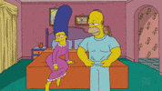 The Simpsons gif. Wearing a nightgown, Marge watches on the edge of the bed in anticipation as Homer removes his shirt, revealing a chiseled chest and abdomen before flexing his biceps in her direction. Marge responds excitedly, curling her toes and bringing her hands to her chest as she says, “Ooohh!”