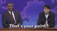 Video gif. Saturday Night Live castmember Mikey Day and guest host Ryan Gosling are dressed as Beavis and Butt-head for a sketch. Day and Gosling are sitting in the front row of a talk show audience. The two of them are staring straight ahead with goofy smiles on their faces. 