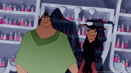 Cartoon gif. Pacha and Kuzco from Emperor's New Groove are in a dark room and a spotlight is on them. Both stare wide-eyed and shrug their shoulders at the same time.