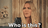 SNL gif. In front of beige curtains, a blonde woman in a leather jacket looks left of frame, puzzled and somewhat annoyed. Text, "Who is this?"