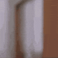 Video gif. A man chewing gives a big thumbs up in a doorway as if approving of the food.