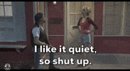 Video gif. Saturday Night Live castmember Mikey Day and guest host Ryan Gosling are dressed as Beavis and Butt-head for a sketch. Day and Gosling are sitting in the front row of a talk show audience. The two of them are staring straight ahead with goofy smiles on their faces. 