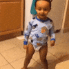 Video gif. A toddler in a diaper dances by shaking his legs and twirling his arms