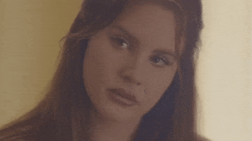 Celebrity gif. A disappointed Lana Del Rey looks sadly at the ground.
