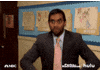 Parks and Recreation gif. Aziz Ansari as Tom looks at someone off screen and throws a bunch of dollar bills into the air. 