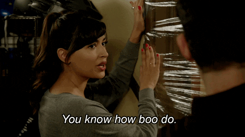 TV gif. Hannah Simone as Cece in New Girl holds cellophane across a door frame. Looking to a man on her right, she smirks coyly, cocks her head to one side, and says, "You know how boo do."