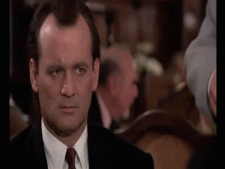Movie gif. Bill Murray as Frank Cross in Scrooged darts his eyes around, confused.