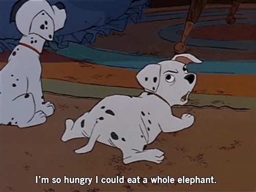 Disney gif. In 101 Dalmatians, a sitting puppy frowns while a puppy lying down looks over his shoulder and says "I'm so hungry I could eat a whole elephant," which appears as text.