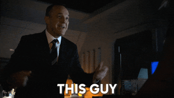 TV gif. Clark Gregg as Phil Coulson On Agents of Shield points to himself with both hands and gives a big enthusiastic smile as he says, “This guy.”