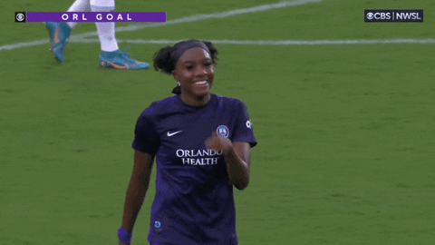 Sports gif. Messiah Bright of the Chicago Red Stars walks across the field with a smile on her face, waving a finger in front of her mouth like she's shushing someone. 