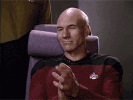 TV gif. Patrick Stewart as Picard in Star Trek sits in his chair, nods and gives a slow clap and a discerning glance.