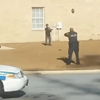 Friendly Police Officer Plays Football With Young Boy
