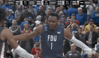 Sports gif. A player from the Fairleigh Dickinson Knights gives another player on the team a low five and they both scream, inches away from each other's faces. A crowd of fans watches from the stands in the background. Logo reads, "March Madness."