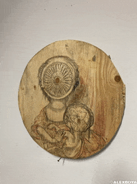 Photo gif. Sketched upon a circular wood slab, a mother holds her baby, but her face has been swallowed up by a turbine. The baby's brain can be seen through the top of his head.