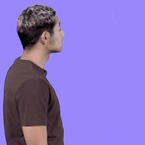Video gif. A man looks around before startling and turning towards us with a smile and a wave. Text, "Oh! Hi.!"