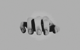 Digital art gif. Black and white shot of fingers slowly tapping a desk, one finger landing at a time.