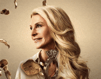 Sponsored gif. Photo of Joan Vassos of The Golden Bachelorette, gold animated rose petals falling all around her. Text, "The Golden Bachelorette."