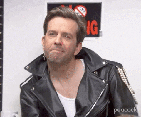The Office gif. Ed Helms as Andy wears a black leather jacket and a dangling silver cross earring in one ear. He squints his eyes and shakes his head. Text, "I'm Sorry What?"