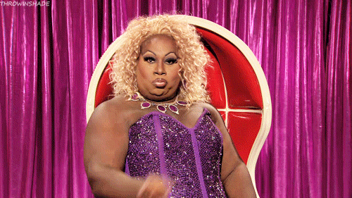 Celebrity gif. Wearing a blonde curly wig and a sparkly purple bustier, Latrice Royale snaps her fingers while craning her neck to the side with sass.
