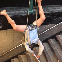 Man Hangs Upside Down While Playing Flute in NYC Subway Station