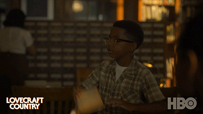 TV gif. In Lovecraft Country, a young boy throws a book on a table at the library in frustration and storms off.