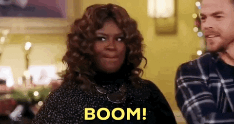 TV gif. Retta on A Legendary Christmas. She's hyped up and is standing in a living room as she says, "BOOM!" while shaking her head and smiling.