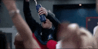 TV gif. In a crowd of people cheering, Charlie Hiscock as Will on Ted Lasso pours champagne into a sports drink bottle and shakes his head while exhaling.