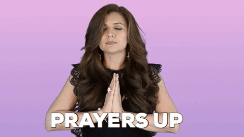 Video gif. A woman with folded hands and closed eyes bows her head. Text, "Prayers up."