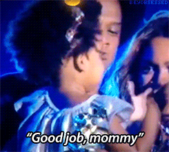 Celebrity gif. Jay-Z holds Blue Ivy Carter up to a microphone as she claps and says "good job, mommy."