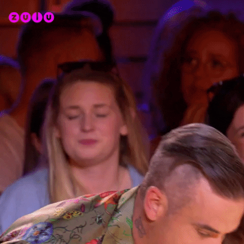 Reality TV gif. Robbie WIlliams on the X Factor leans forward as he enunciates each word that appears one at a time. Text, "Thank god you arrived!"