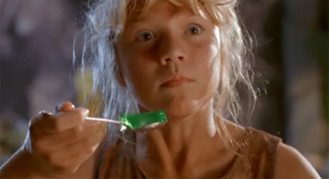 Movie gif. Trembling in fear, Ariana Richards as Lex in Jurassic Park holds a shaking spoonful of green jello.
