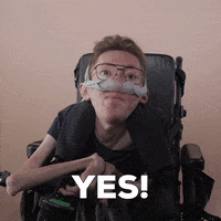 Reaction gif. A mobility-impaired white man using a power chair, a ventilator, and wearing retro-crossbar glasses decisively and excitedly says, "Yes!"