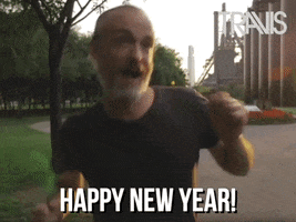 Celebrity gif. Fran Healy of Travis dances, hopping up and down, with his arms bouncing around almost like the chicken dance. He has a wide smile on his face that is full of happiness and joy. The text says, “Happy New Year!”