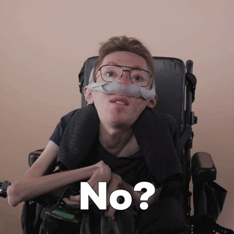 Reaction gif. A mobility-impaired white man using a power chair, a ventilator, and wearing retro-crossbar glasses raises an eyebrow with guarded eyes, asking, "No?"
