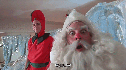 Movie gif. Jeff Gillen as Santa Claus in A Christmas Story zooms his face toward us somewhat menacingly with widened eyes while saying "ho, ho, ho!" which appears as text. Drew Hocevar as an elf looks on in the background