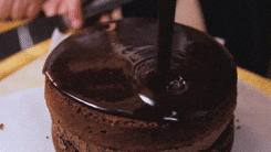 bolo em espanhol 

DESCRIÇÃO DA IMAGEM: Alguém está colocando calda em cima de um bolo de chocolate recheado. 