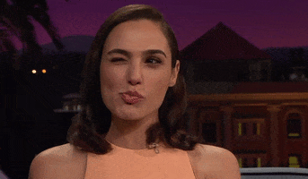 TV gif. Gal Gadot is on the Late Late Show with James Cordon. She winks and makes a kissy face in sync with the wink.