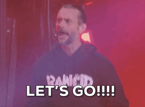 Sports gif. CM Punk on AEW Rampage screams "Let's Go!!!" while lights flash and smoke rises behind him.